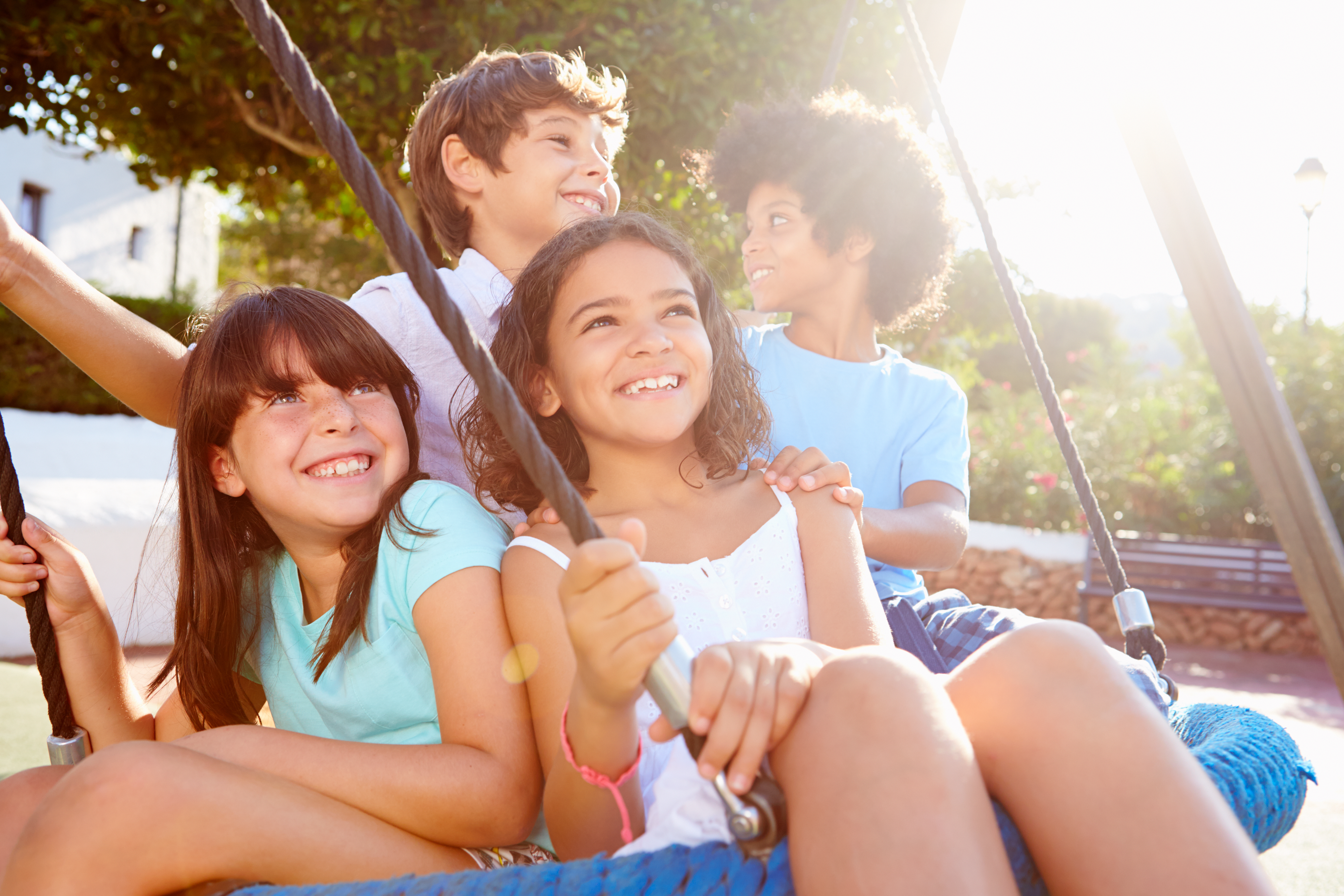 Group of children swinging on tire swing in playground